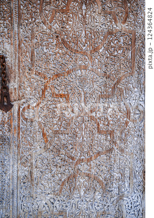 traditional Uzbek retro carved pattern kandakori on vintage old wooden door in Uzbekistan 124364824