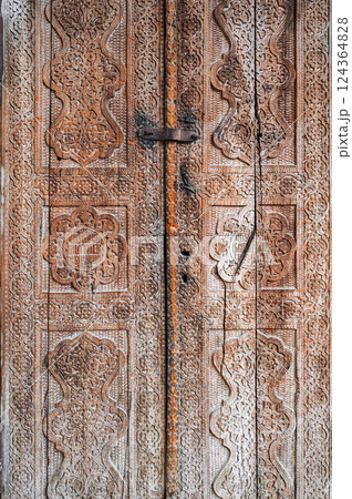 traditional Uzbek carved pattern on vintage wooden door in Uzbekistan traditional Uzbek carved pattern on vintage wooden door in Uzbekistan 124364828