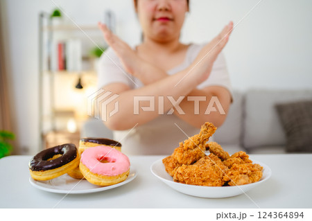 A woman refuses to eat fast food, fried chicken and donuts on her plate to lose weight 124364894