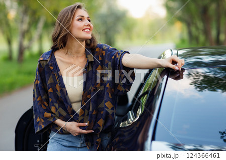 Happy woman driver at car smiling. Cute young happy brunette female driving car vehicle 124366461