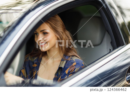 Happy woman driver at car smiling. Cute young happy brunette female driving car vehicle Happy woman driver at car smiling. Cute young happy brunette female driving car vehicle 124366462