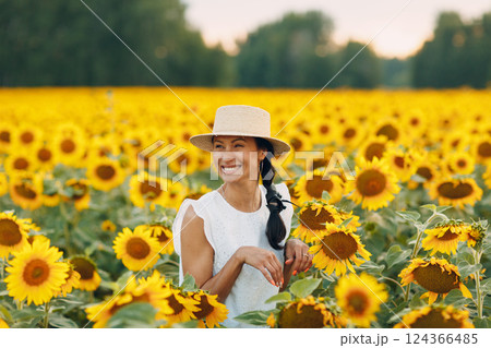 Beautiful young woman in a hat on a field of sunflowers 124366485