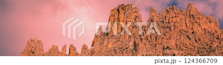 Mountain landscape in the evening. The Dolomites Alps against the sunset sky. Sella Pass, Grohmannspitze, Selva di Val Gardena, Bolzano, Italy. Horizontal banner 124366709