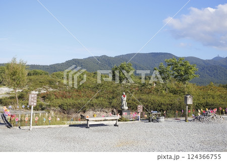 風車が並ぶ池と水子地蔵供養御本尊 124366755