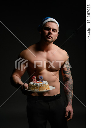 Man celebrating 32nd birthday with cake in festive atmosphere Man celebrating 32nd birthday with cake in festive atmosphere 124367028