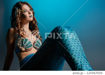 Mermaid cosplay with intricate body art in an aquatic-themed setting 124367030