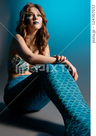 Woman poses elegantly in mermaid cosplay with intricate body art Woman poses elegantly in mermaid cosplay with intricate body art 124367032