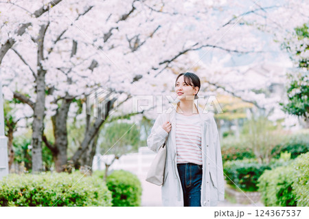 桜並木を散歩する若い女性 124367537