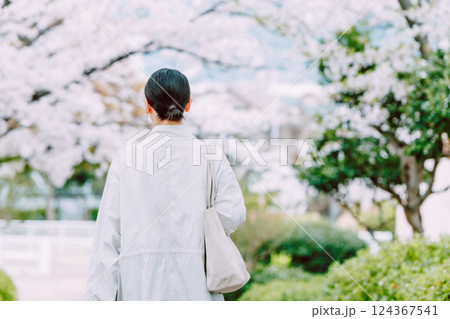 桜並木を散歩する若い女性の後ろ姿 124367541