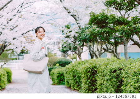 桜並木を散歩する若い女性 124367593