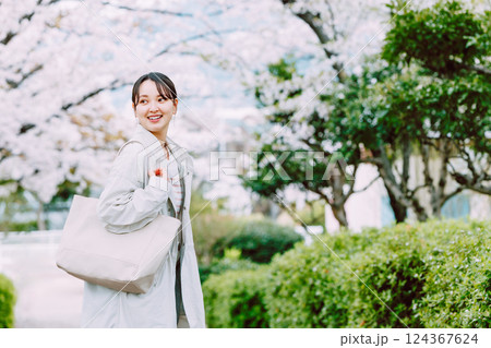 桜並木を散歩する若い女性 124367624