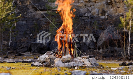 Beautiful Crackling Campfire in a Rocky Landscape , Sunrise , Authentic Place Beautiful Crackling Campfire in a Rocky Landscape , Sunrise , Authentic Place 124368111