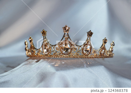 Luxury golden crown with citrine gemstones and diamonds on light background Luxury golden crown with citrine gemstones and diamonds on light background 124368378