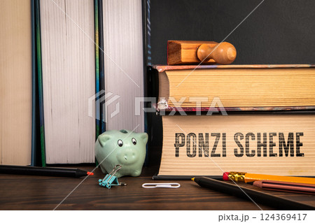 Ponzi Scheme. Stack of books on a wooden shelf 124369417