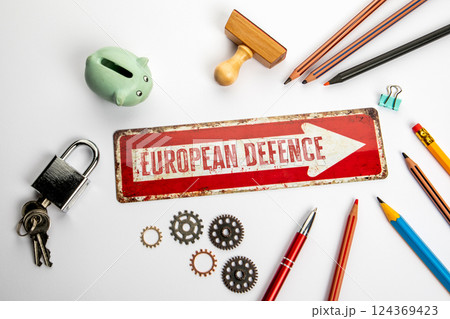 European defence. Red direction arrow with text on white office desk 124369423
