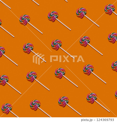 Pattern of lollipops on an orange colorful background. Sweet candy concept. Colorful food. Pattern of lollipops on an orange colorful background. Sweet candy concept. Colorful food. 124369793