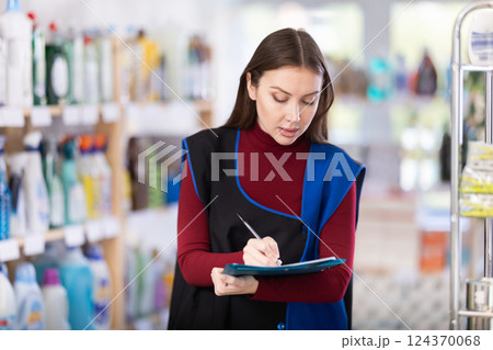 Young woman seller conducting inventory in store 124370068