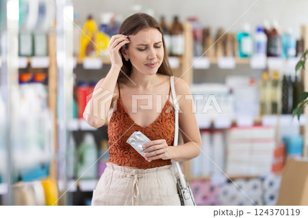 Tired young woman struggling with headache in store Tired young woman struggling with headache in store 124370119