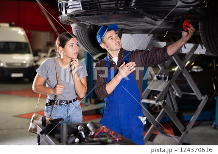 Young guy mechanic posing at car service station Young guy mechanic posing at car service station 124370616