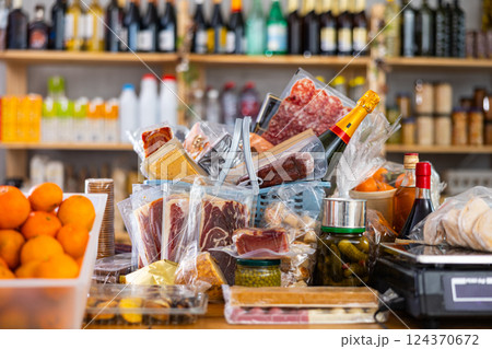 Assortment of goods on counter, basket with products on table near scale Assortment of goods on counter, basket with products on table near scale 124370672