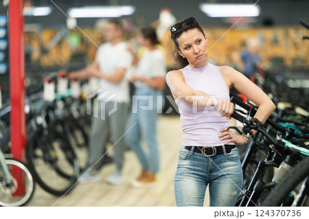 Adult woman choosing bike in store Adult woman choosing bike in store 124370736