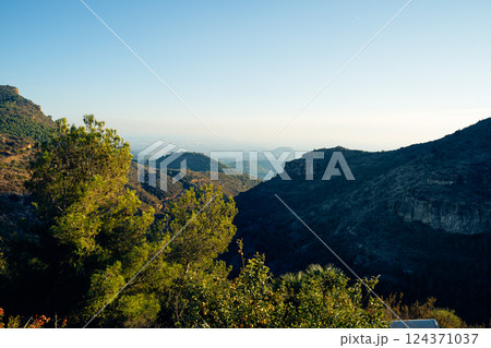 Serene Mountain Landscape with Lush Greenery and Clear Sky Serene Mountain Landscape with Lush Greenery and Clear Sky 124371037