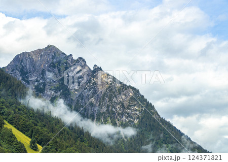 Mountain landscape mountains green fields forest clouds in Vorarlberg Austria. 124371821