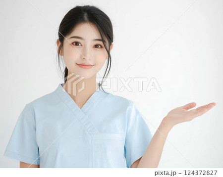 手のひらを上に上げ案内する若い女性。病院の看護師。 124372827
