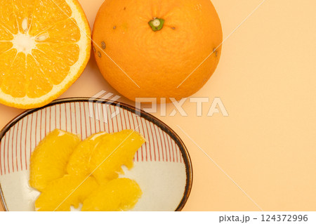 紅夏みかんの断面とむいた果肉が小皿に乗っている素材写真 124372996