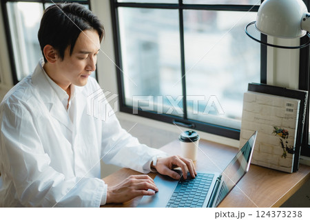 静かなオフィスでデータ解析に集中する若手研究者 124373238