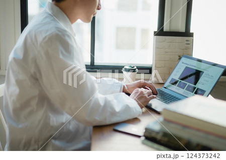 静かなオフィスでデータ解析に集中する若手研究者 124373242