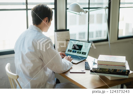 静かなオフィスでデータ解析に集中する若手研究者 124373243
