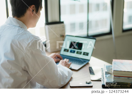 静かなオフィスでデータ解析に集中する若手研究者 124373244