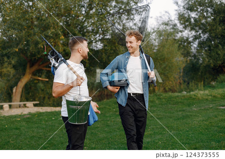 Friends is ready to fishing. Men holding a fishing equipment. One man wearing rose t-shirt and other blue shirt. 124373555