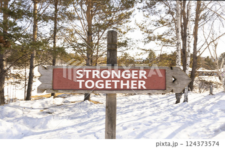 Stronger together symbol. Concept words Stronger together on beautiful wooden road sign. Beautiful forest snow blue sky background. Business, motivational and stronger together concept. 124373574