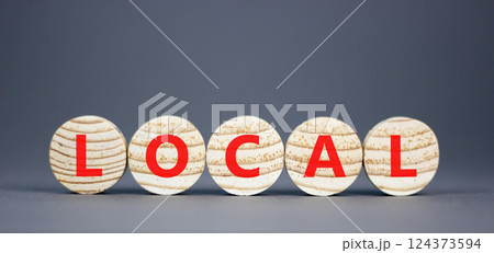 Local symbol. Concept word Local on beautiful wooden circles. Beautiful grey table grey background. Business lifestyle local concept. Copy space. Local symbol. Concept word Local on beautiful wooden circles. Beautiful grey table grey background. Business lifestyle local concept. Copy space. 124373594