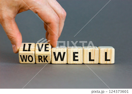 Live or work well symbol. Concept words Live well Work well on wooden cubes. Beautiful grey table grey background. Businessman hand. Business and live or work well concept. Copy space. 124373601