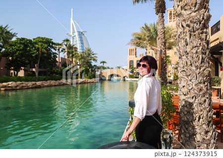 Traveling in Dubai, woman enjoys beautiful view of city architecture Traveling in Dubai, woman enjoys beautiful view of city architecture 124373915