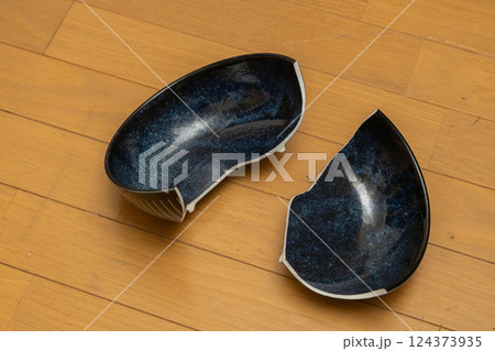 床に落ちて二つに割れた皿 124373935