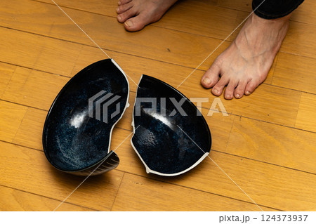 割れた皿と女性の足元　皿を割った人 124373937