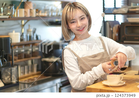 コーヒーを淹れる準備をするカフェの店員 124373949