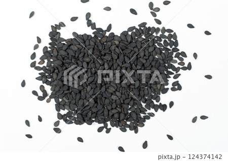 Black sesame seeds scattered on a white background macro top view Black sesame seeds scattered on a white background macro top view 124374142