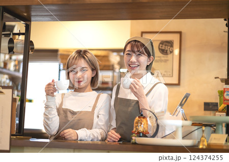 カウンターでコーヒーカップを持つ2人の女性バリスタ 124374255