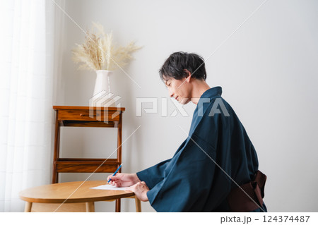 静かなひととき – 和装で手紙を綴る男性 124374487