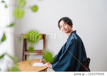 静かなひととき – 和装で手紙を綴る男性 124374504