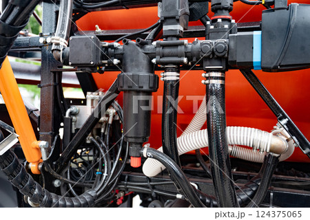 Close-up of industrial pump with green and black components, orange background. 124375065