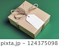 Minimalist eco-friendly gift box with blank white tag and natural twine bow on green background 124375098