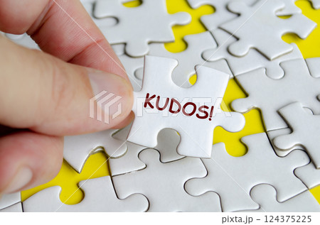 KUDOS text on missing jigsaw puzzle. Outstanding achievement concept KUDOS text on missing jigsaw puzzle. Outstanding achievement concept 124375225