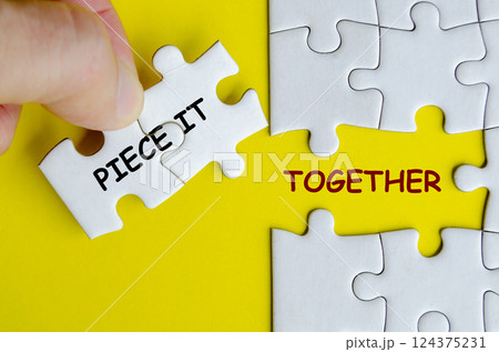 Piece it together text on missing jigsaw puzzle representing teamwork and unity. Teamwork concept 124375231