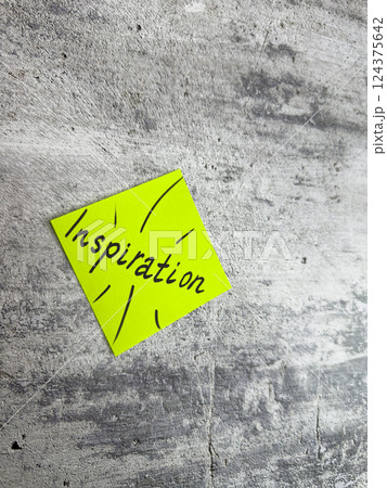 Bright yellow sticky note in a diamond shape featuring the word Inspiration and decorative rays on a textured grey background, symbolizing the spark of creativity and motivating ideas Bright yellow sticky note in a diamond shape featuring the word Inspiration and decorative rays on a textured grey background, symbolizing the spark of creativity and motivating ideas 124375642